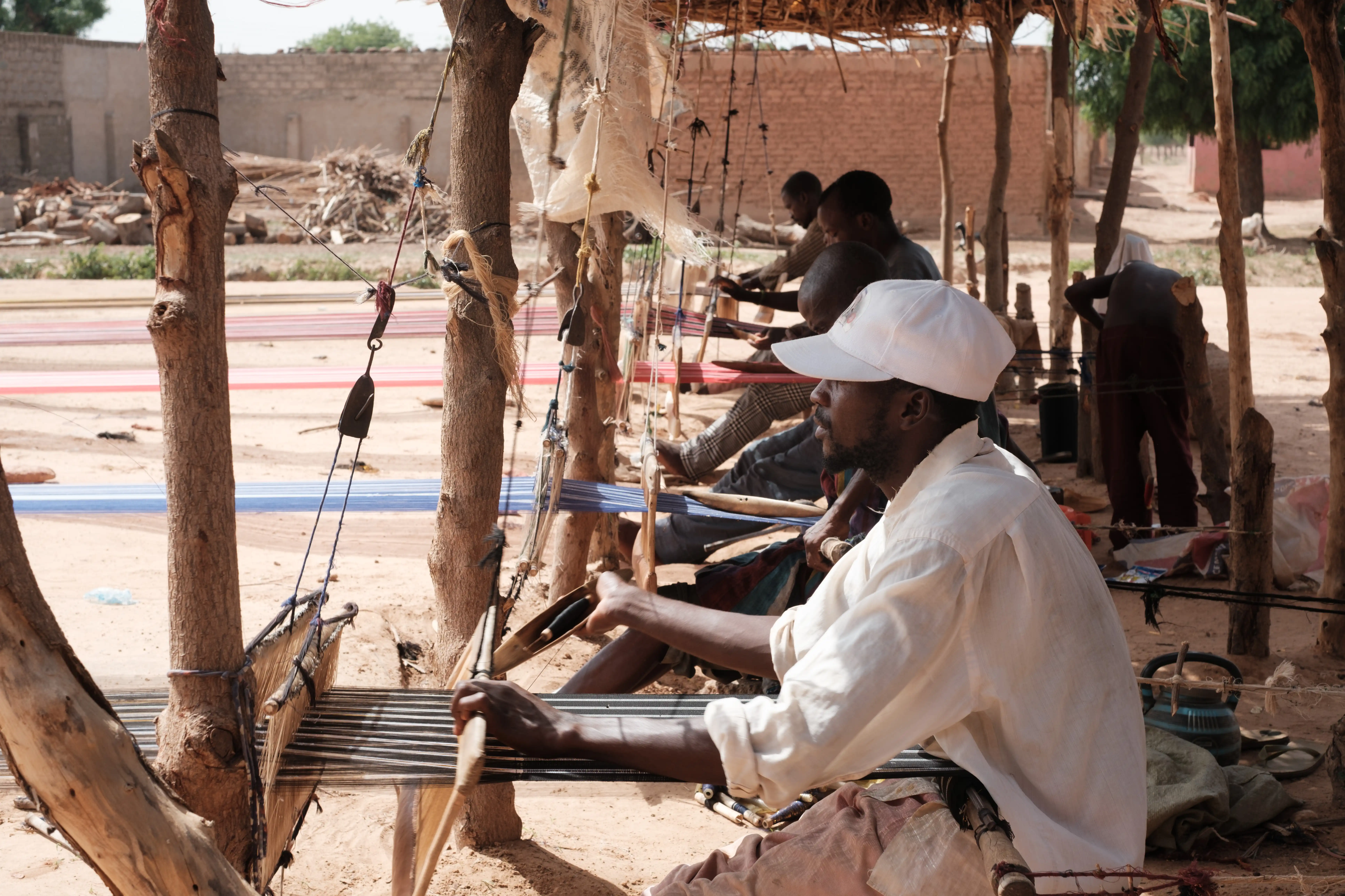 Two artisans collaborating on a loom